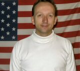 Jeffery standing in front of U.S. flag